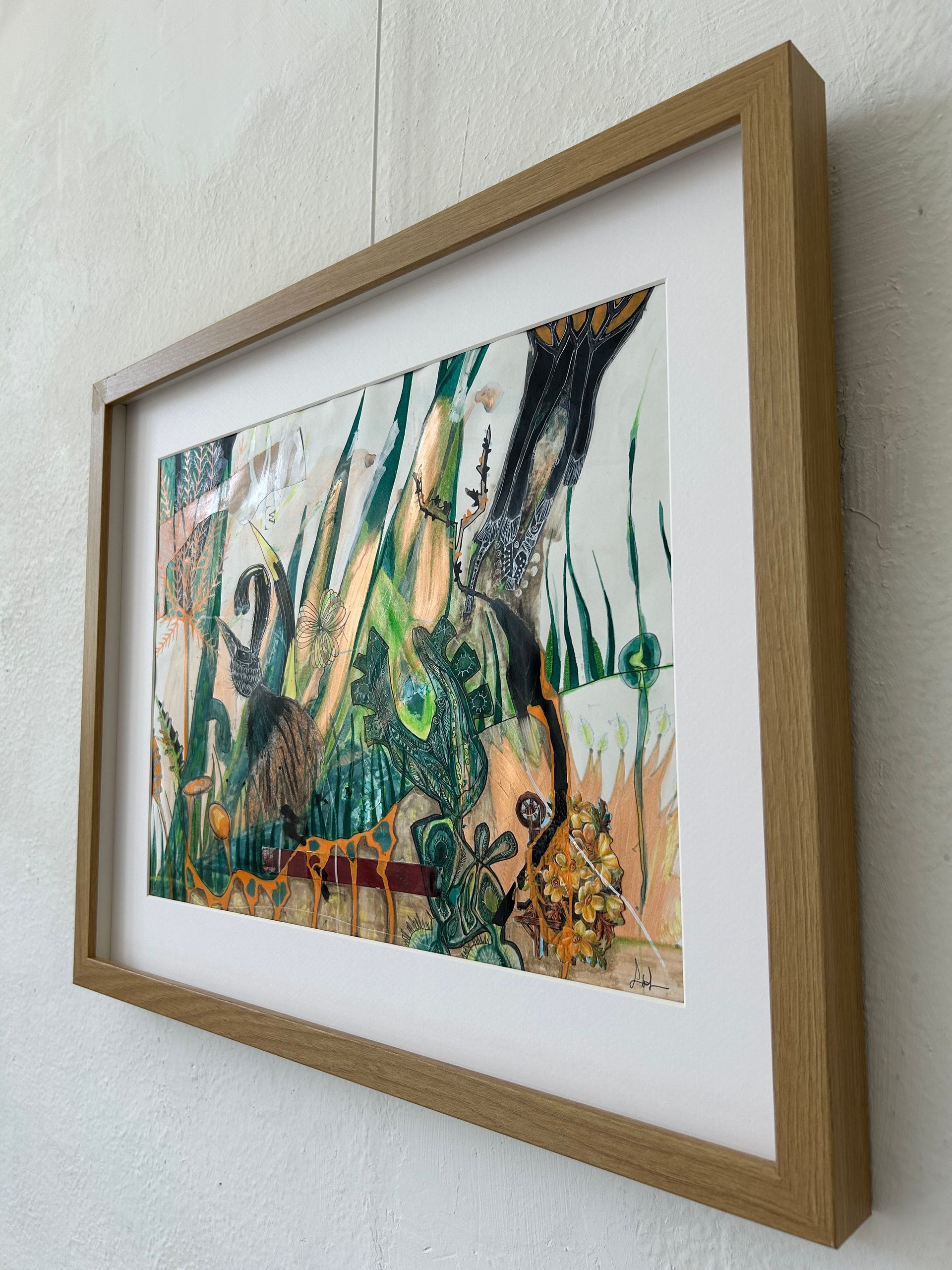 Ingelijst abstract schilderij met groene, beige en zwarte penseelstreken op een witte muur.