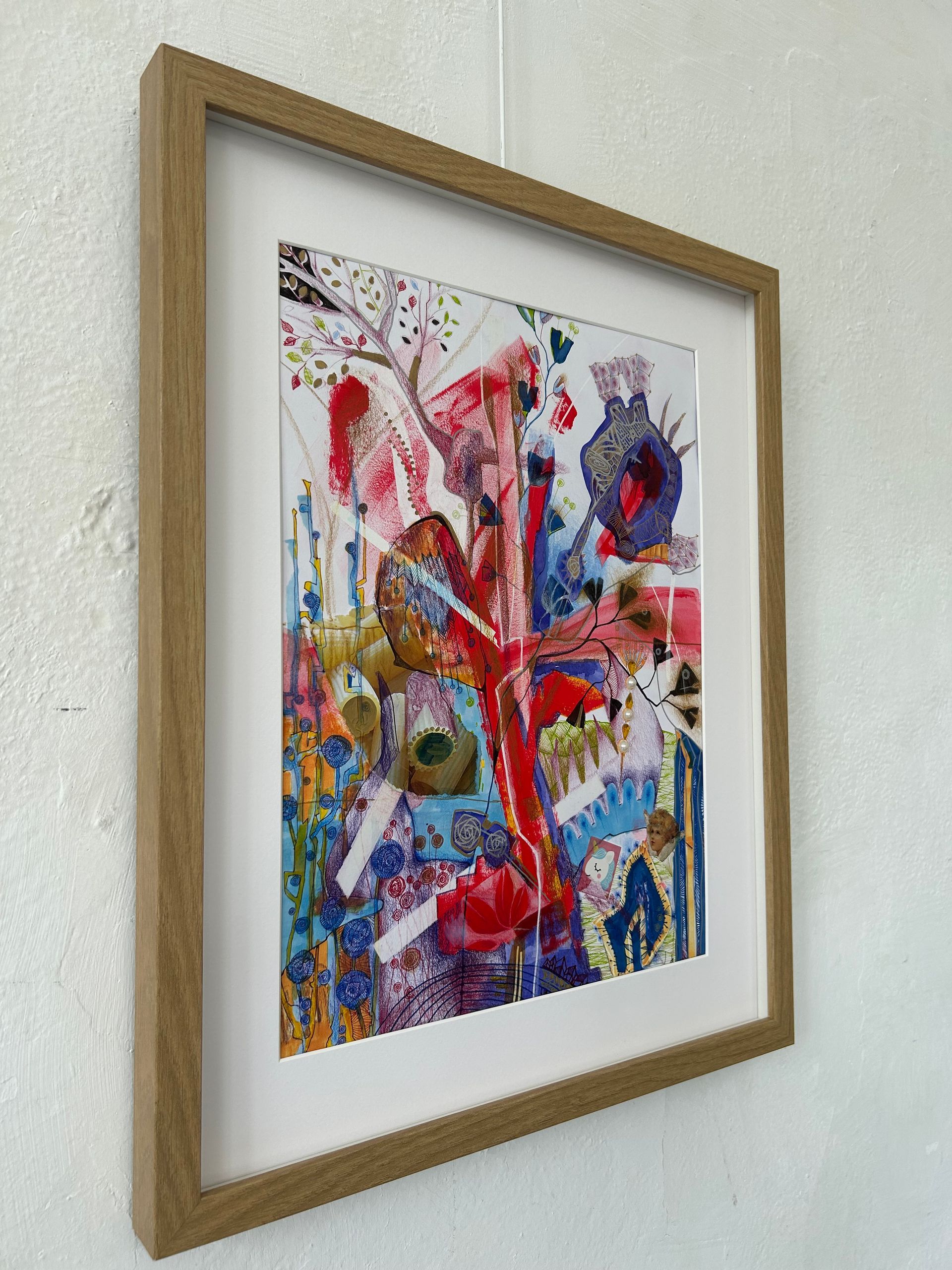 Ingelijst abstract, kleurrijk kunstwerk in gemengde technieken aan een witte muur.