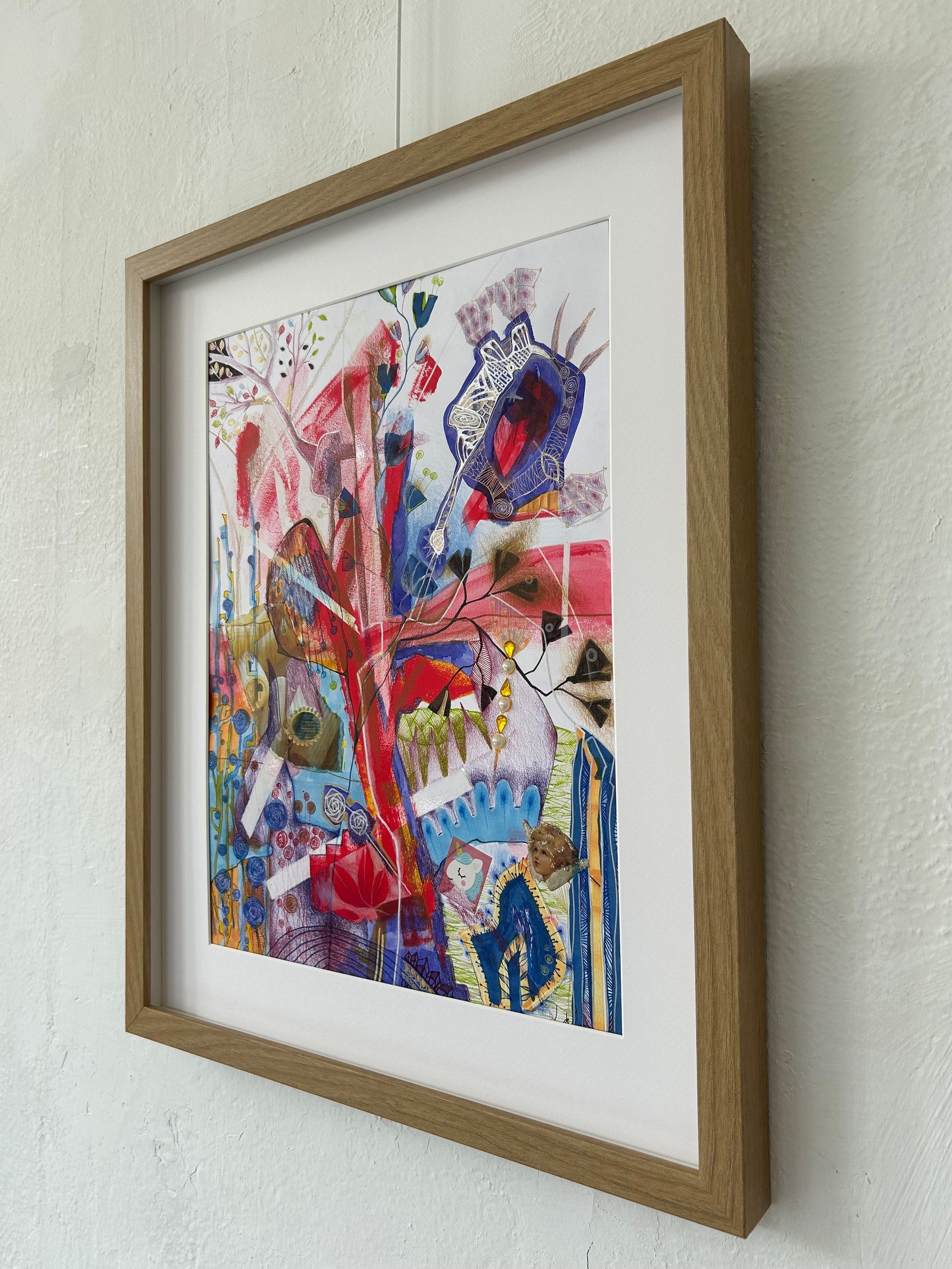 Ingelijst abstract, kleurrijk kunstwerk met rode, blauwe en gele accenten aan de muur.