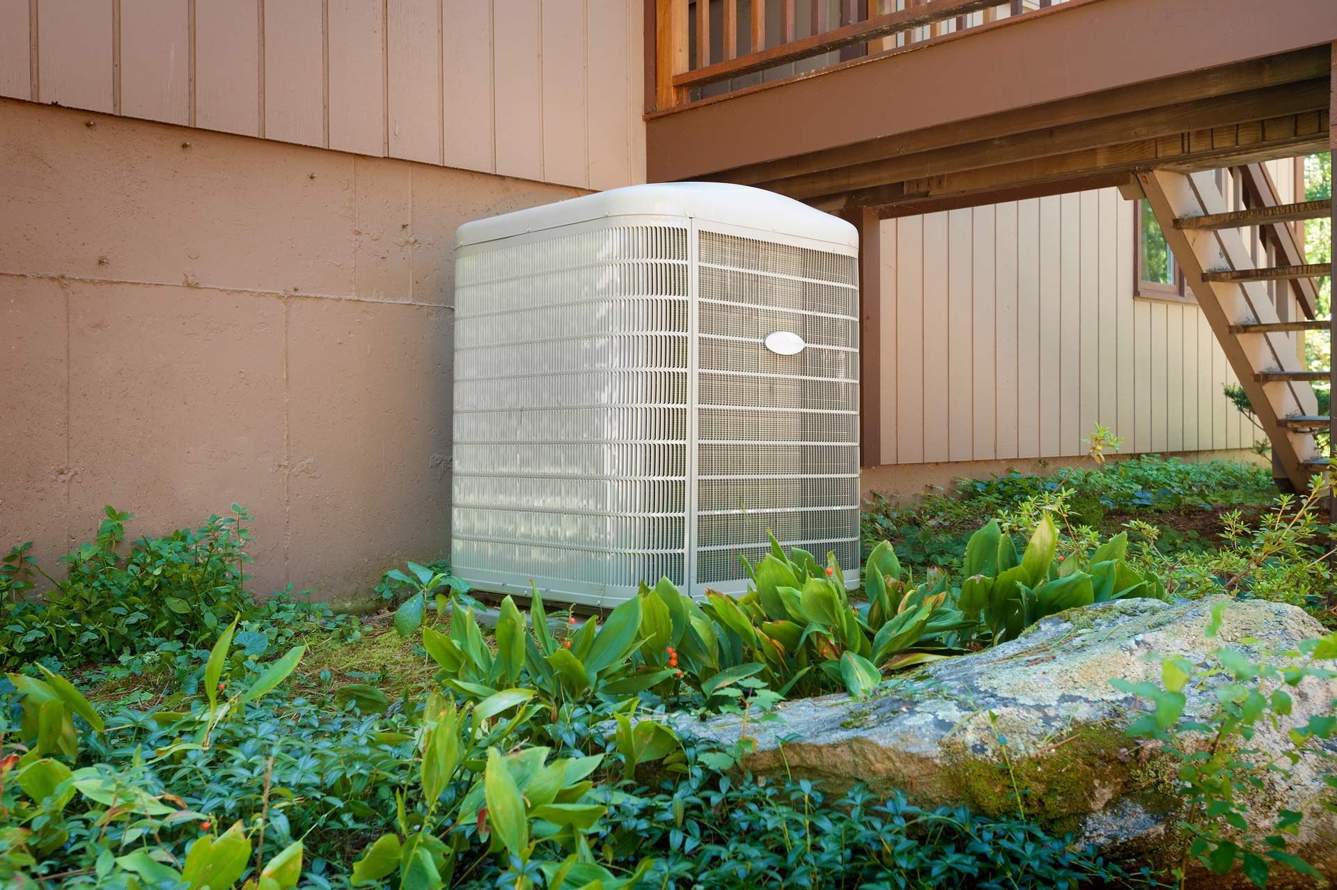 A large air conditioner is sitting on the side of a house.