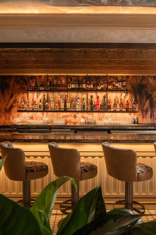 A bar with a row of premium liquor bottles and glasses on it at the Harbour Club members only club in Miami Beach.