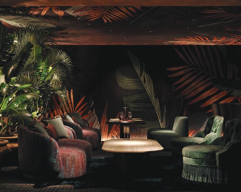 Comfortable lounge chairs set in front of fern plants at the Harbour Club private event venue in Miami Beach.