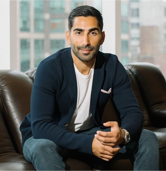 James Julius, founder of the Harbour Club, wearing a blue blazer and sitting on a couch.