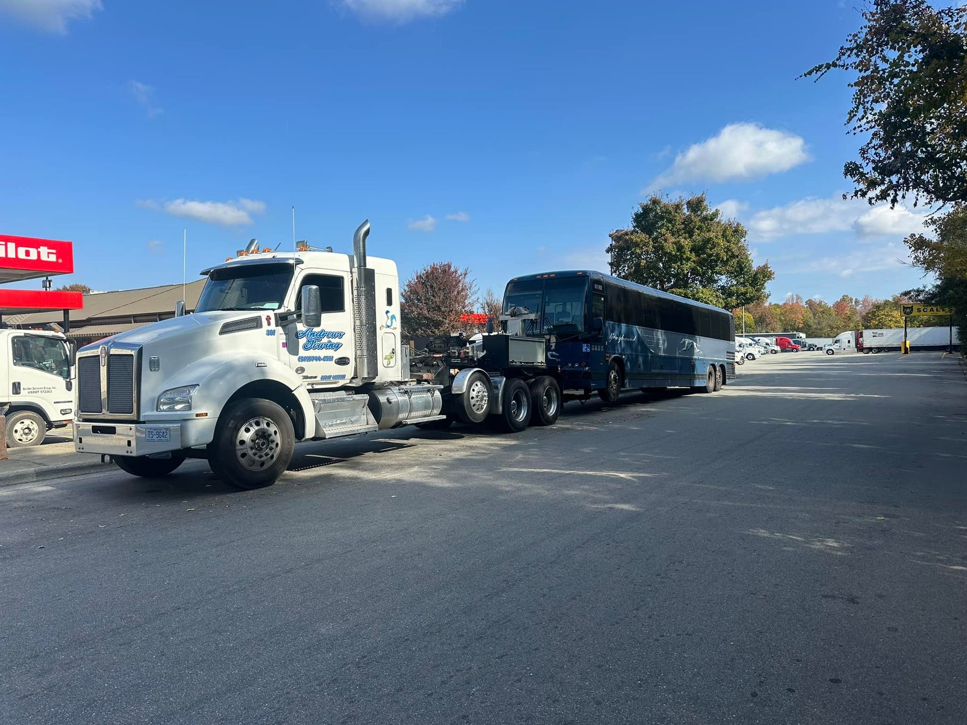 A bus is being towed by a semi truck.