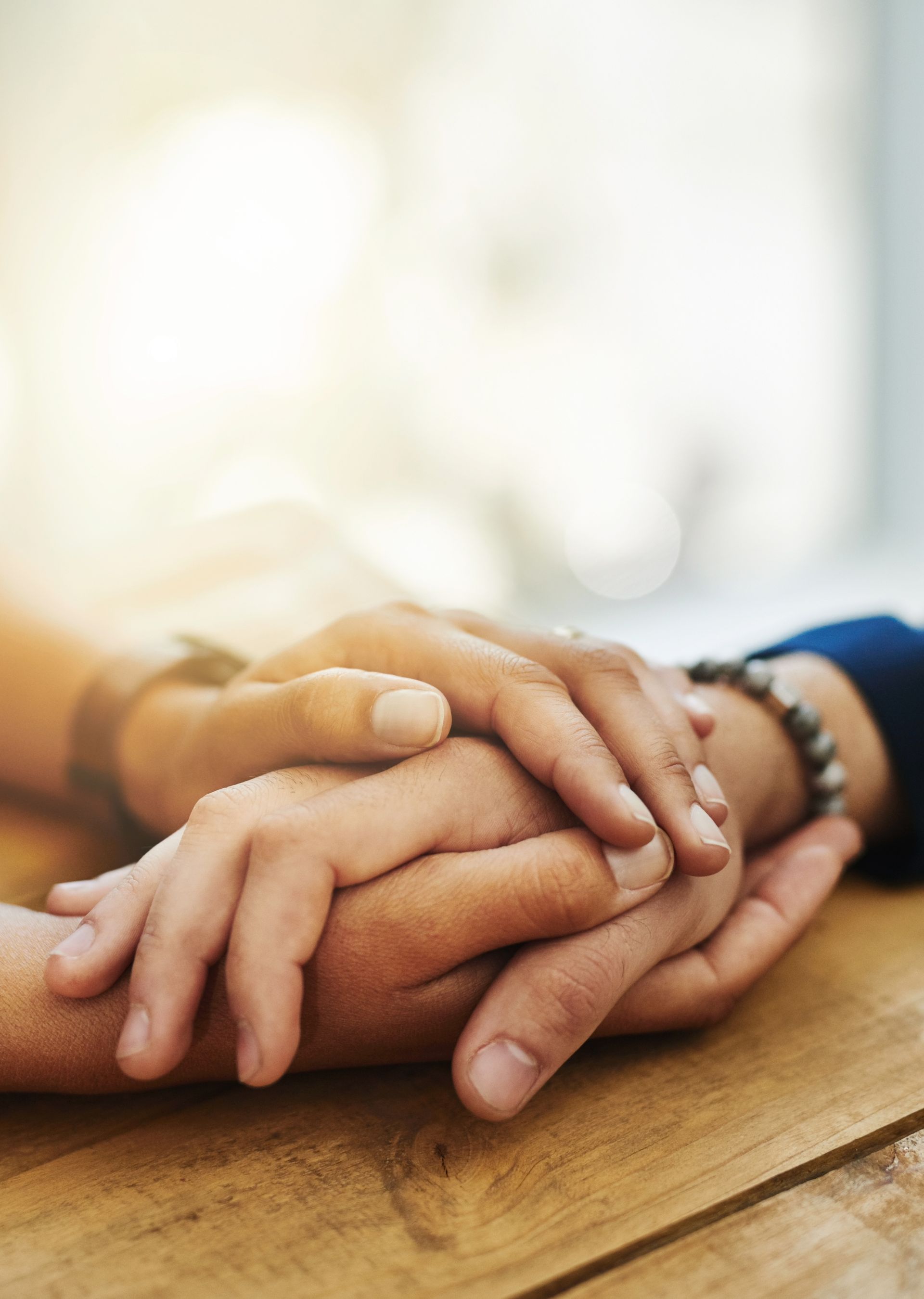 Doctor comforting a patient with a hand on their shoulder in a clinic setting