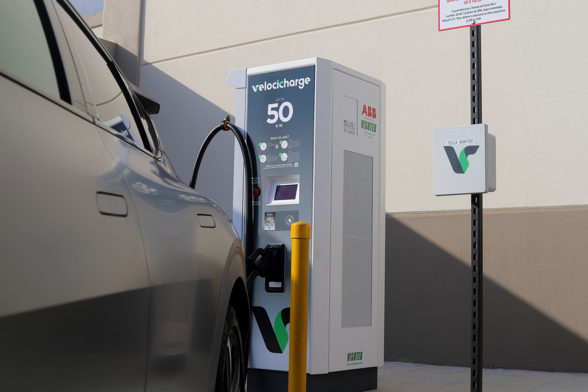 Electric vehicle charging at a white Volta charger. Car plugged in.