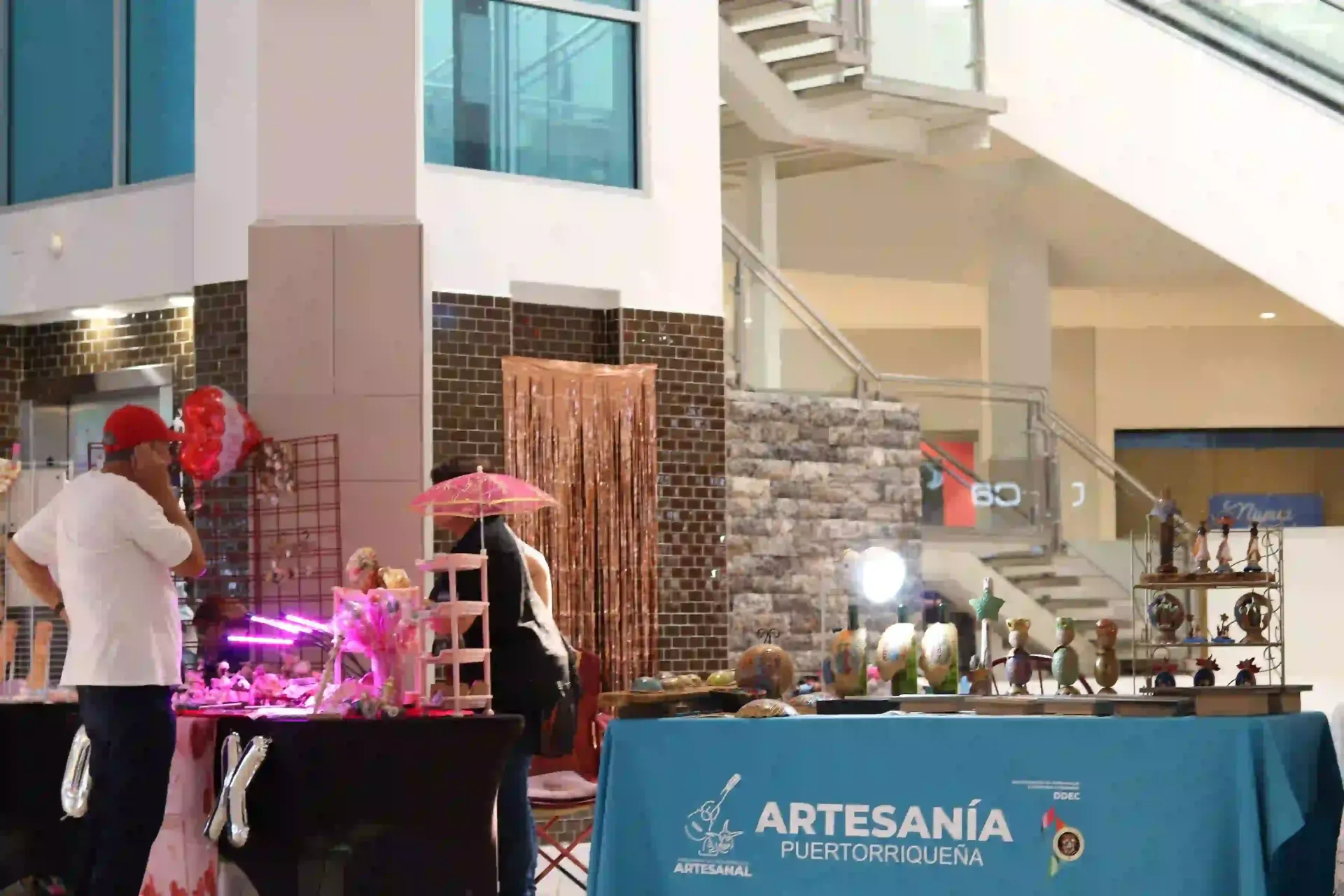 Vendors and merchandise on display are in a bright indoor space in Céntrico Guayama