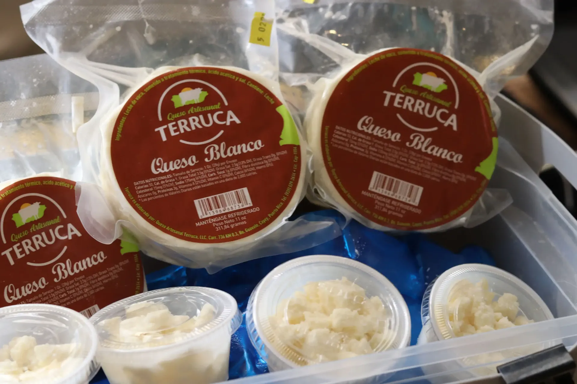Various packaged queso blanco cheese products in a clear container in Céntrico Guayama