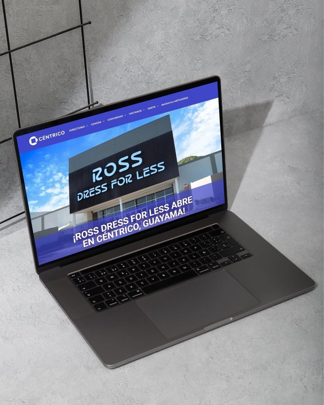 Laptop displaying Ross Dress for Less website; against a light gray, textured wall.