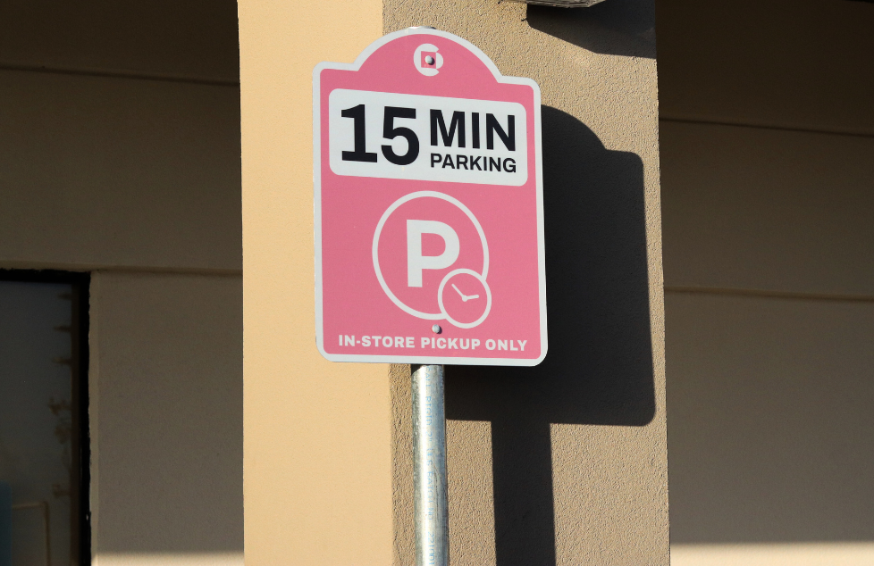 Pink parking sign: 15-minute parking for in-store pickup only.