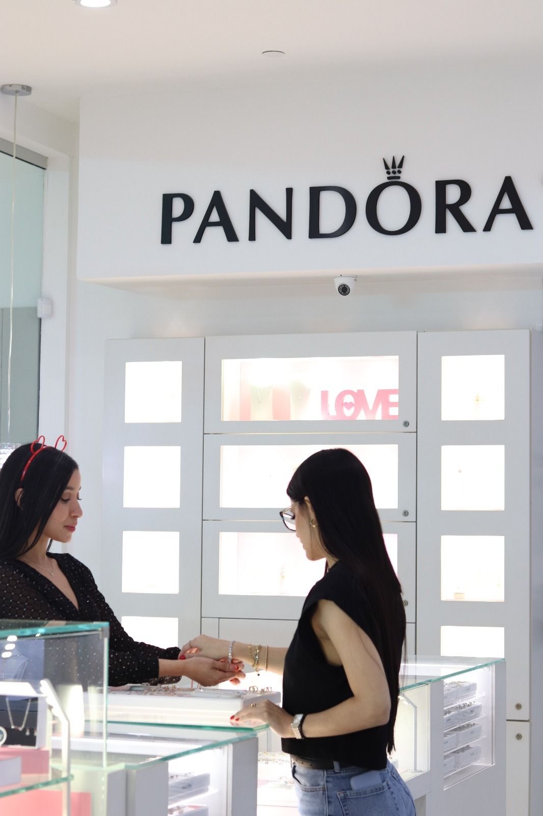 Two women are standing in front of a pandora store