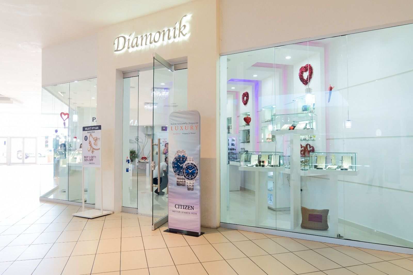 A jewelry store in a mall with a sign in front of it.