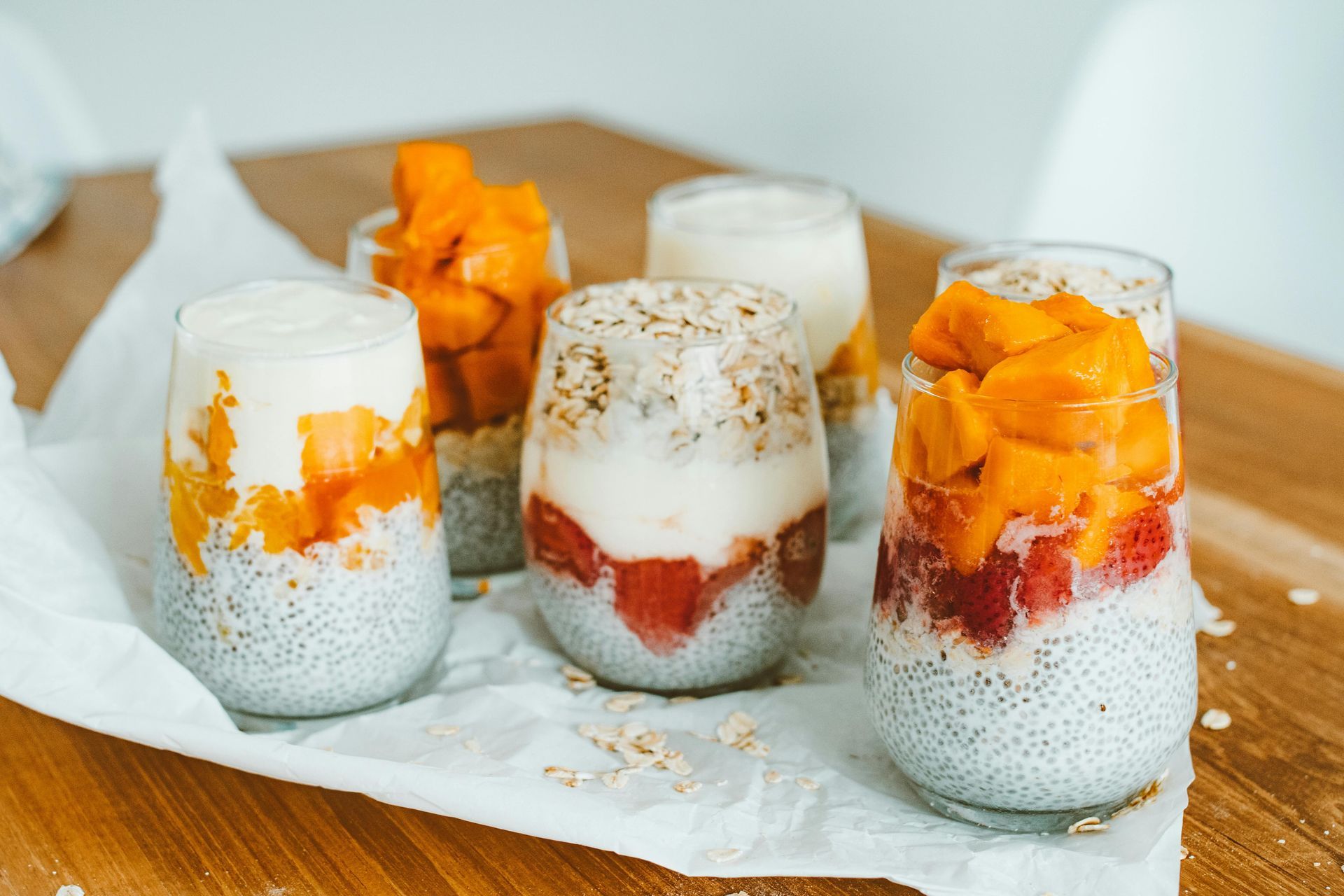There are many different types of food in the glasses on the table.