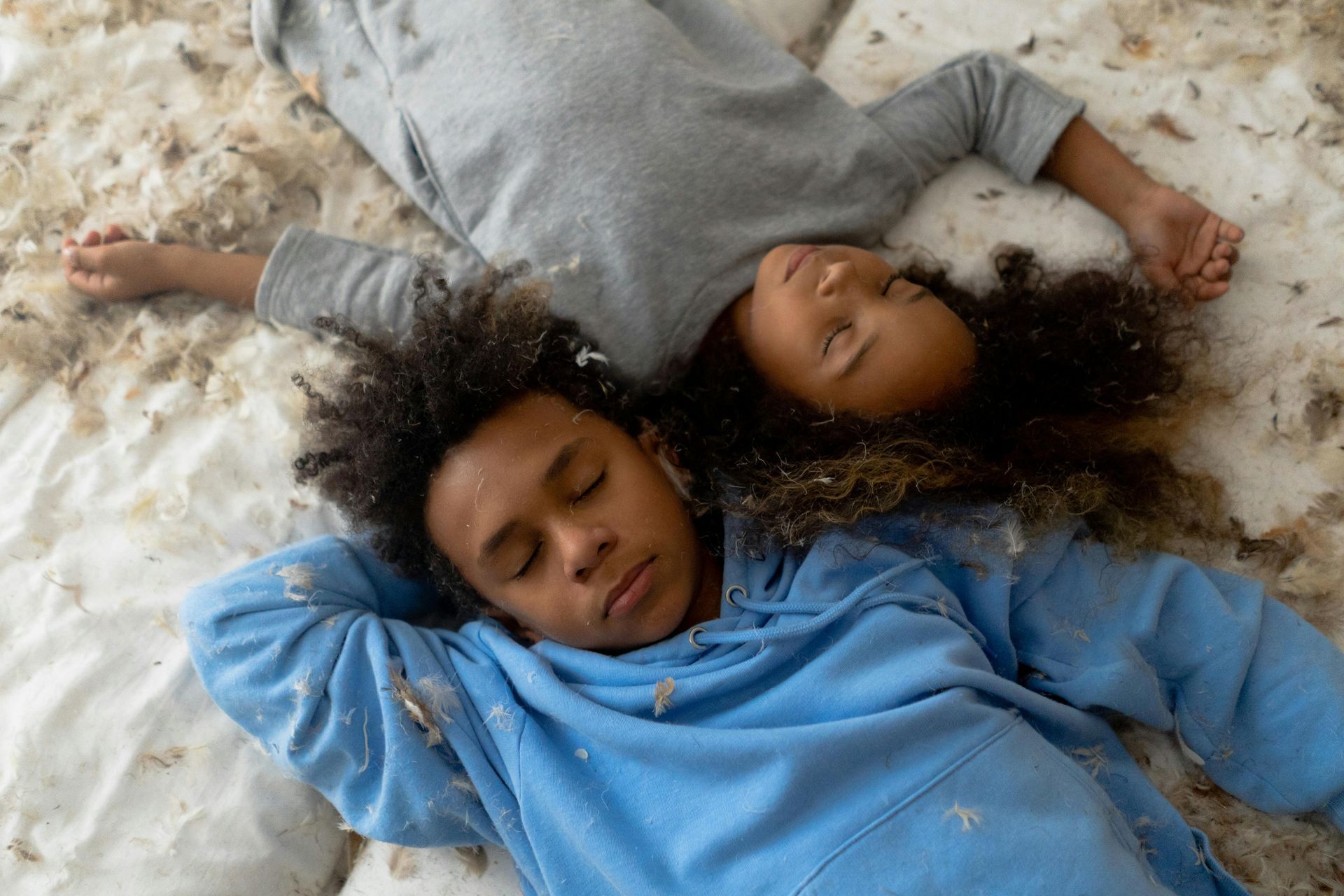 Two children are sleeping on a bed in the snow.