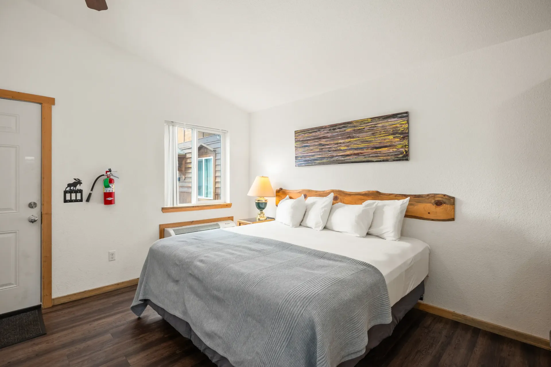 A bedroom with a king size bed and a fire extinguisher on the wall.