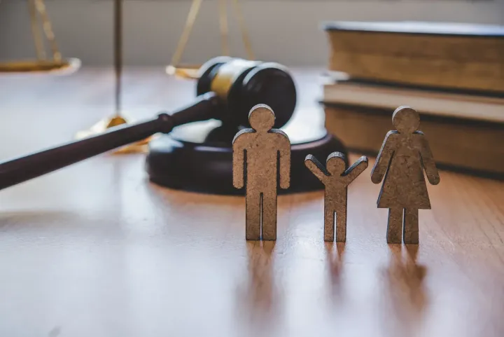 Wooden family figures and gavel on table, representing family law.