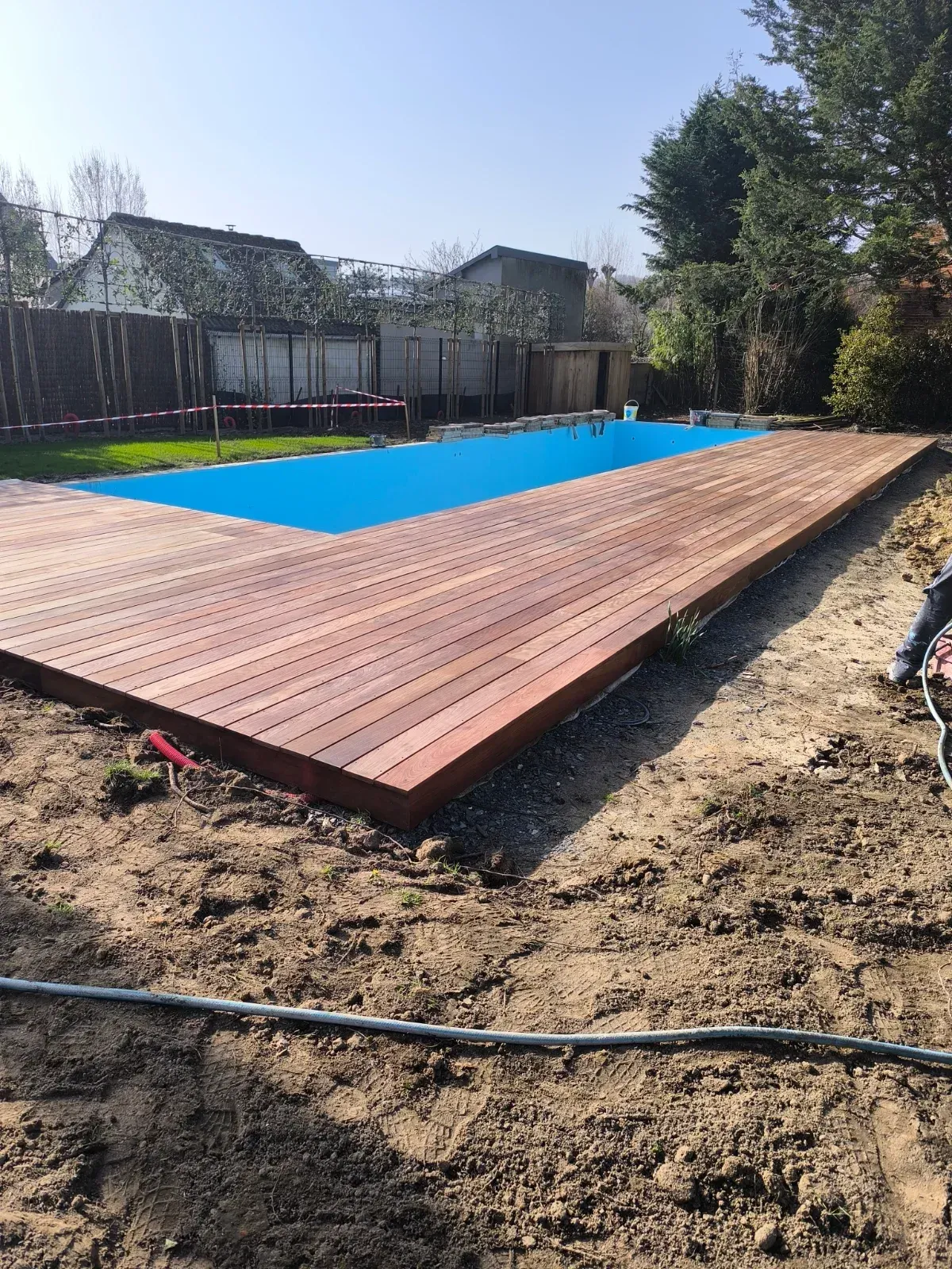 Tour de piscine en bois exotique terminé, liner bleu
