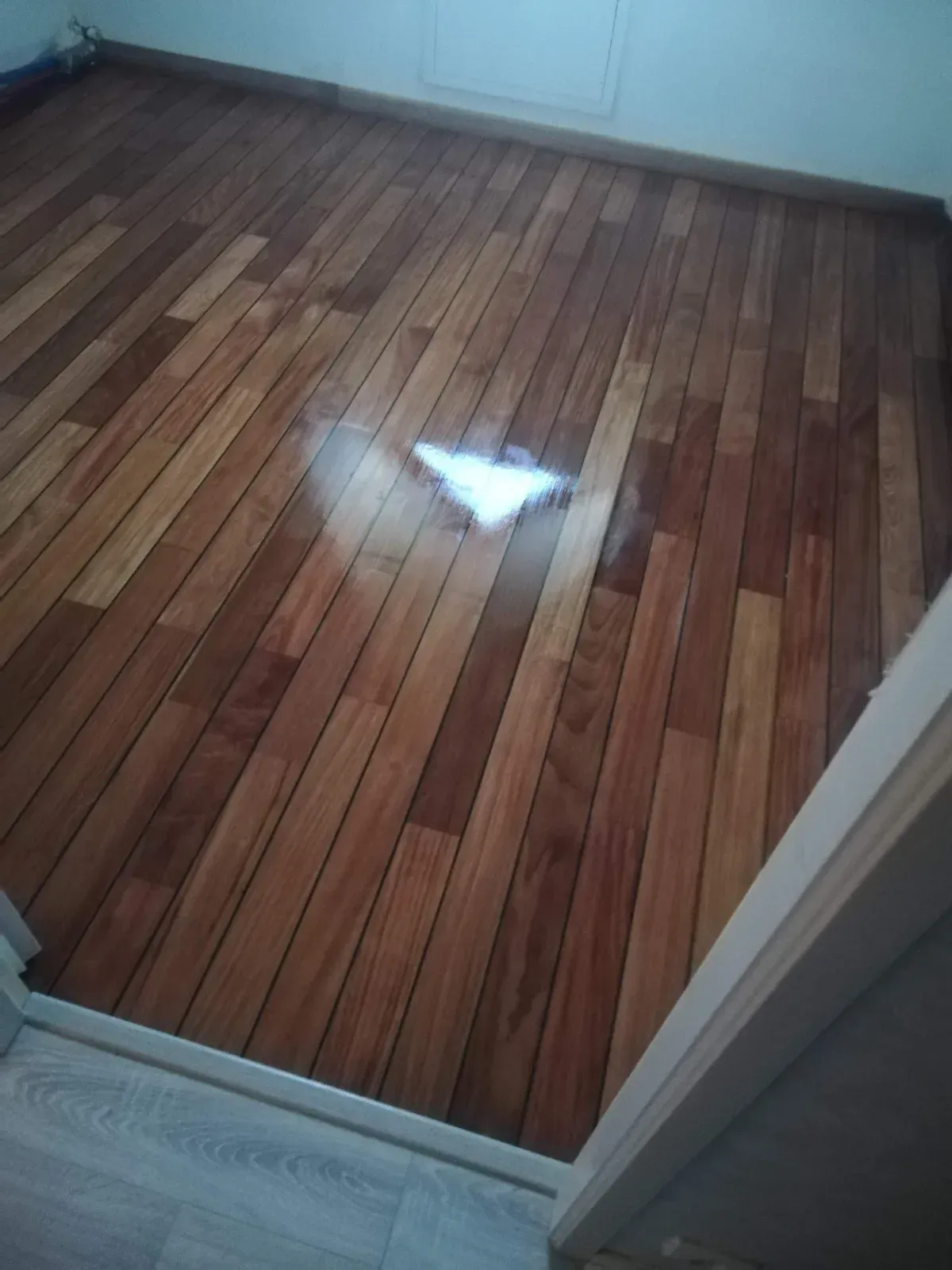 Parquet en bois exotique verni avec jonction propre sur un carrelage