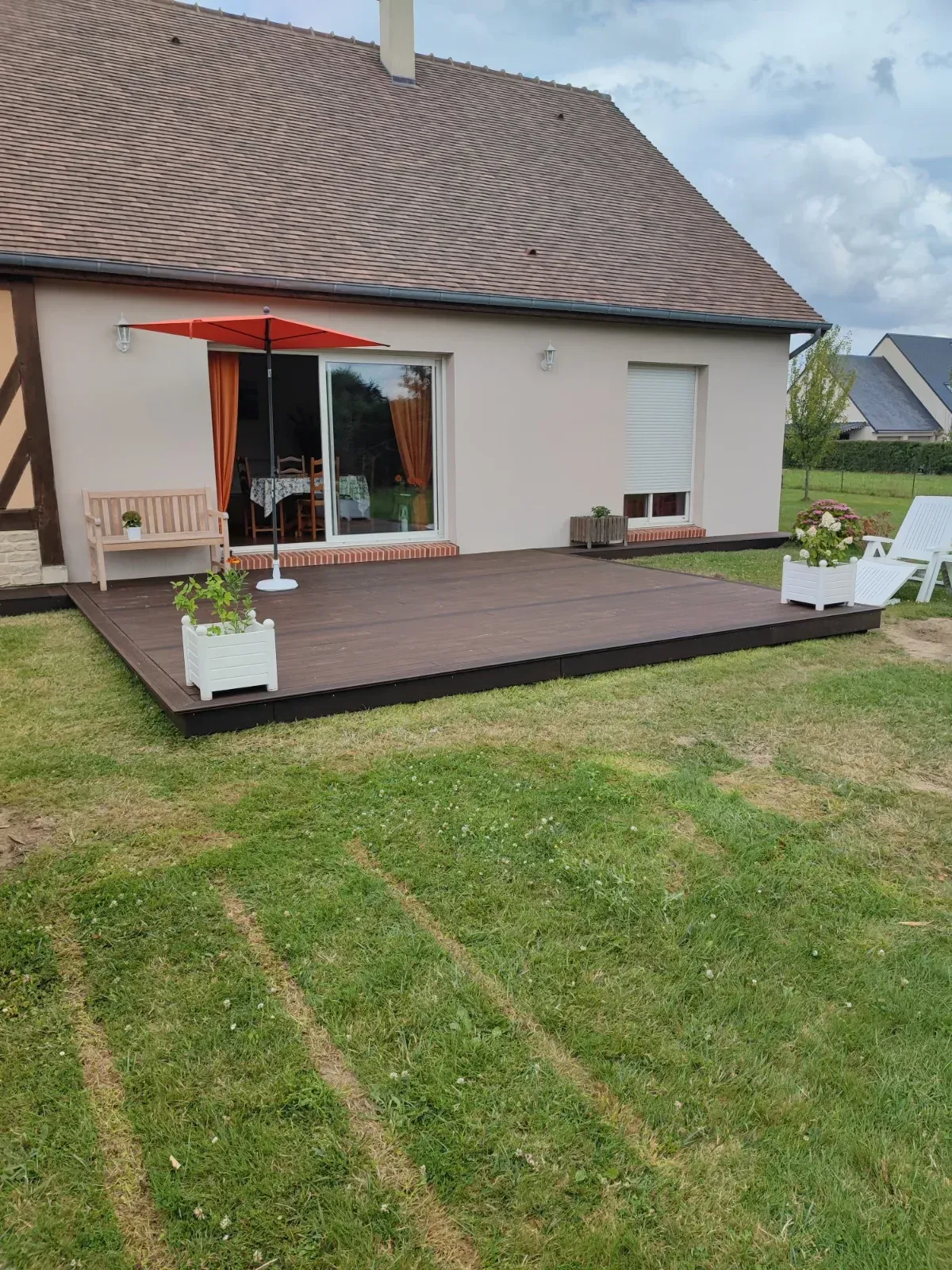 Terrasse en bois exotique et bardage devant une maison à colombages