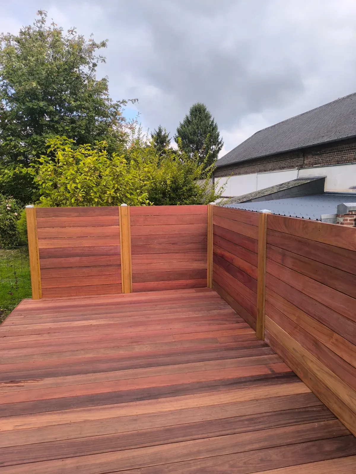 Terrasse en bois exotique avec claustra en lames horizontales