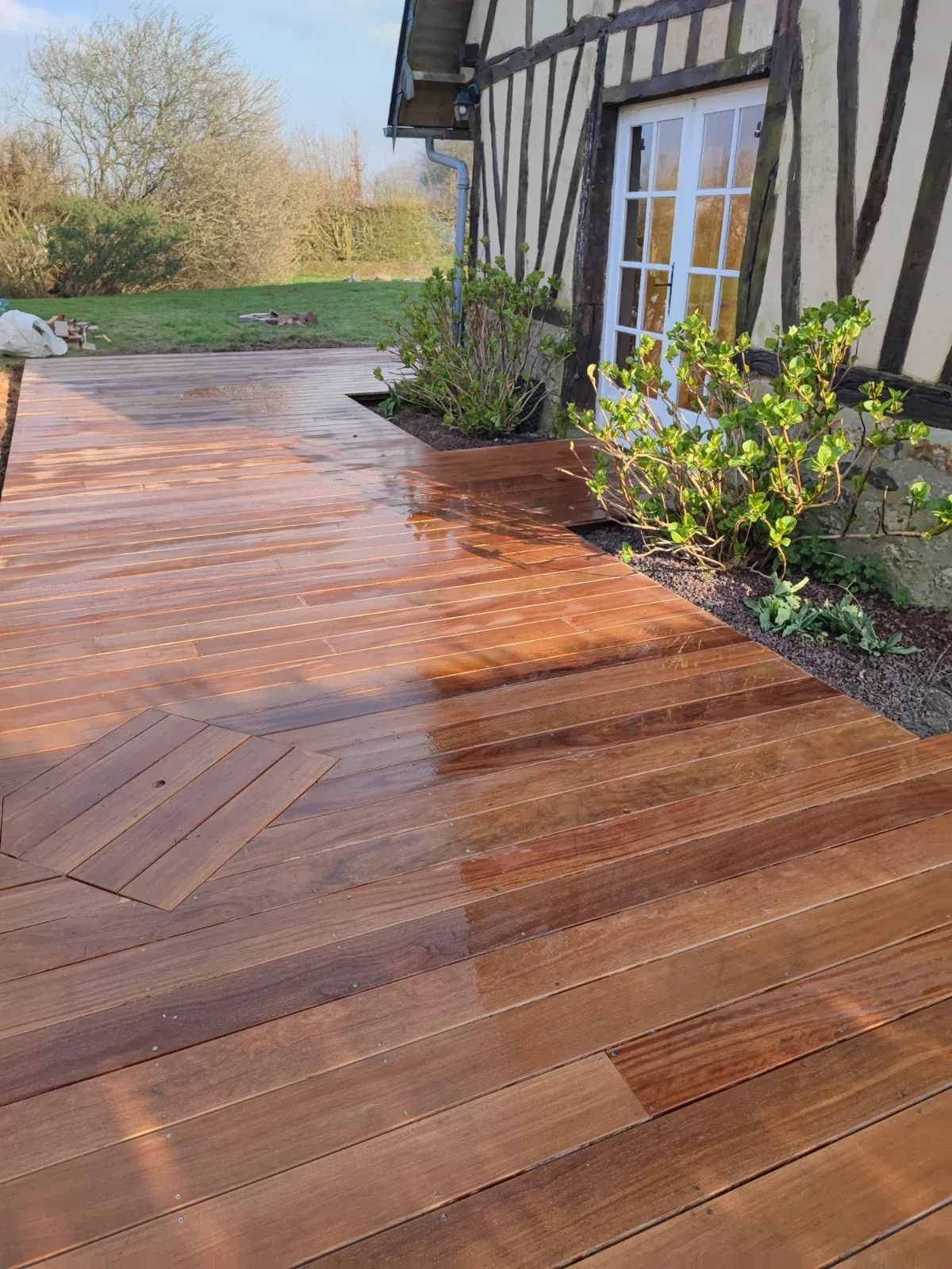 Terrasse en bois exotique au pied d'une maison normande à colombages