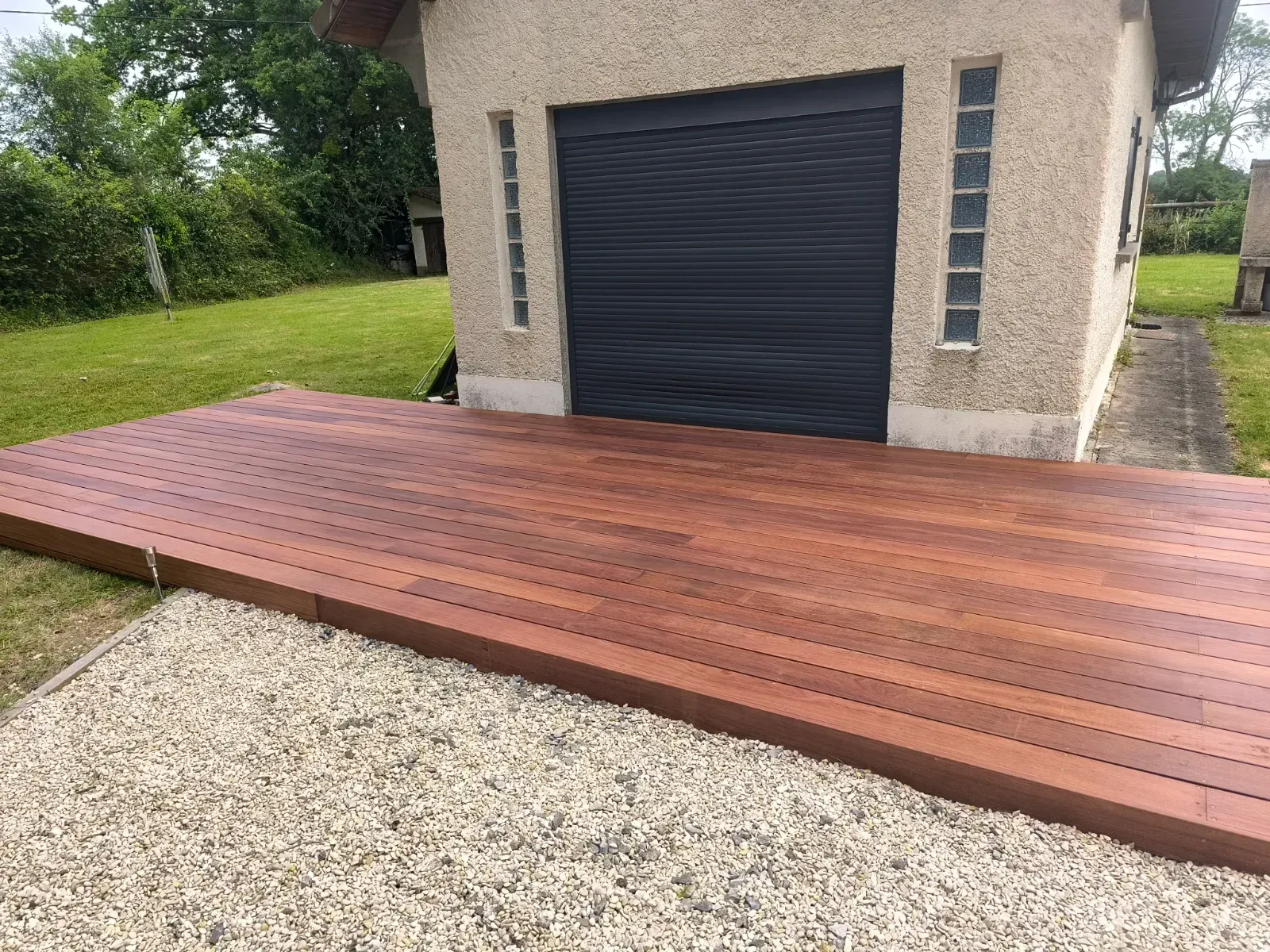 Terrasse en bois exotique devant un garage