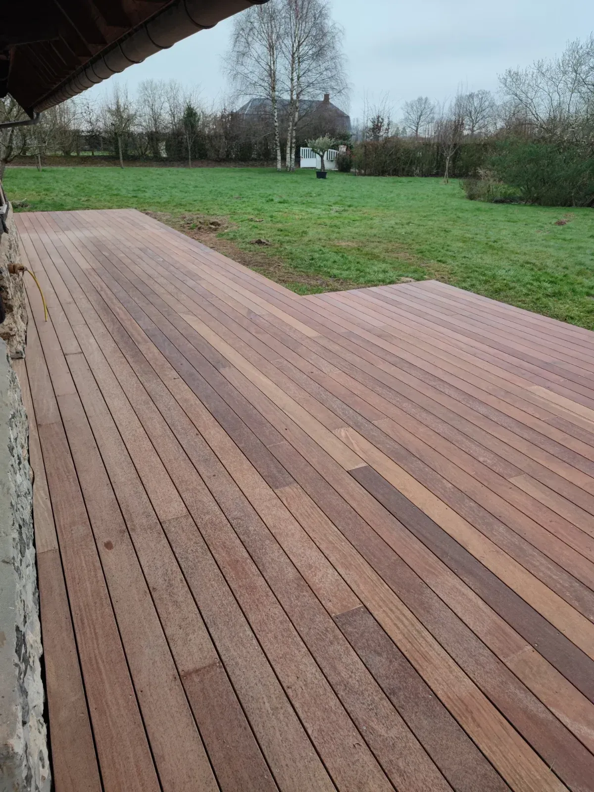Grande terrasse en bois exotique devant une maison à colombages