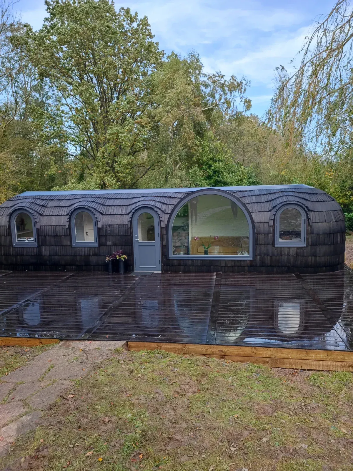 Terrasse en bois résineux devant un studio de jardin en bois