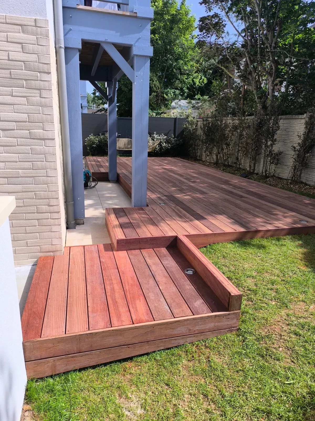 Terrasse en bois exotique multi-niveaux avec banquette intégrée à Deauville