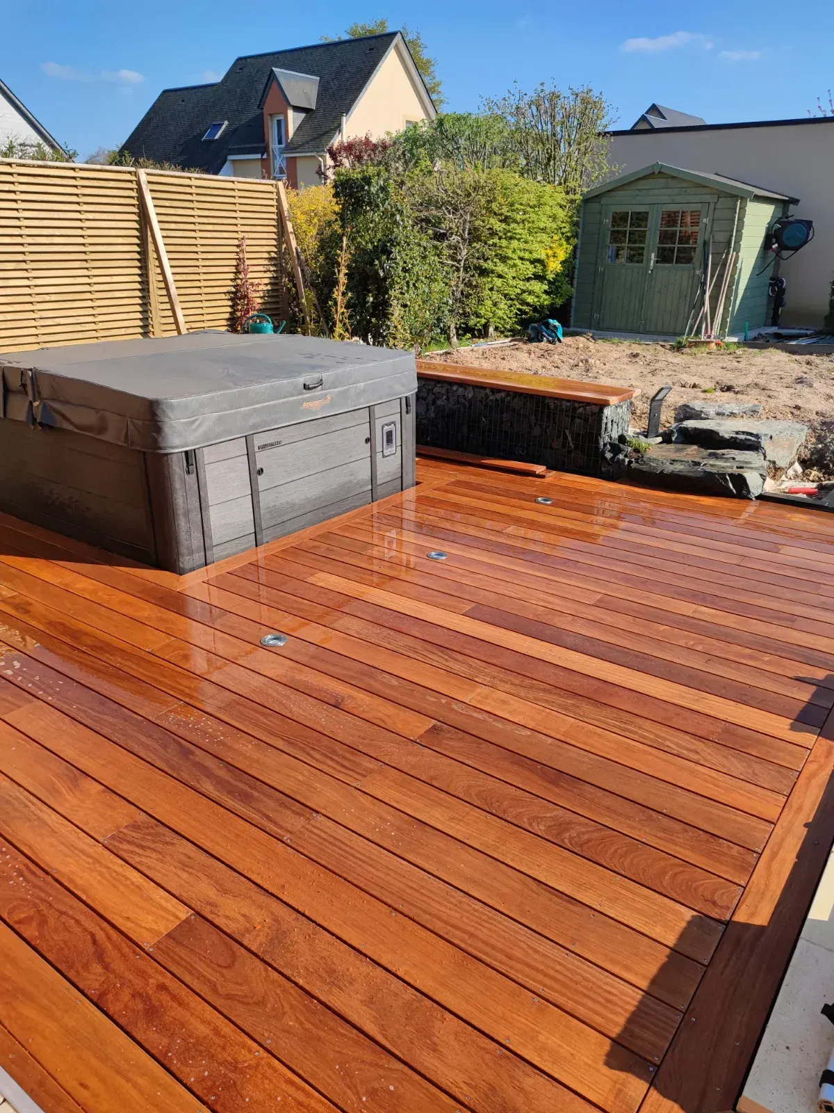 Terrasse en bois exotique saturée après rénovation autour d'un spa