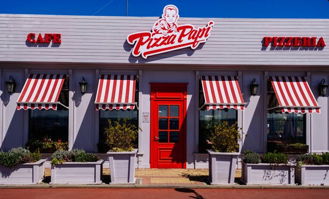 The front of a pizza papi restaurant with red awnings