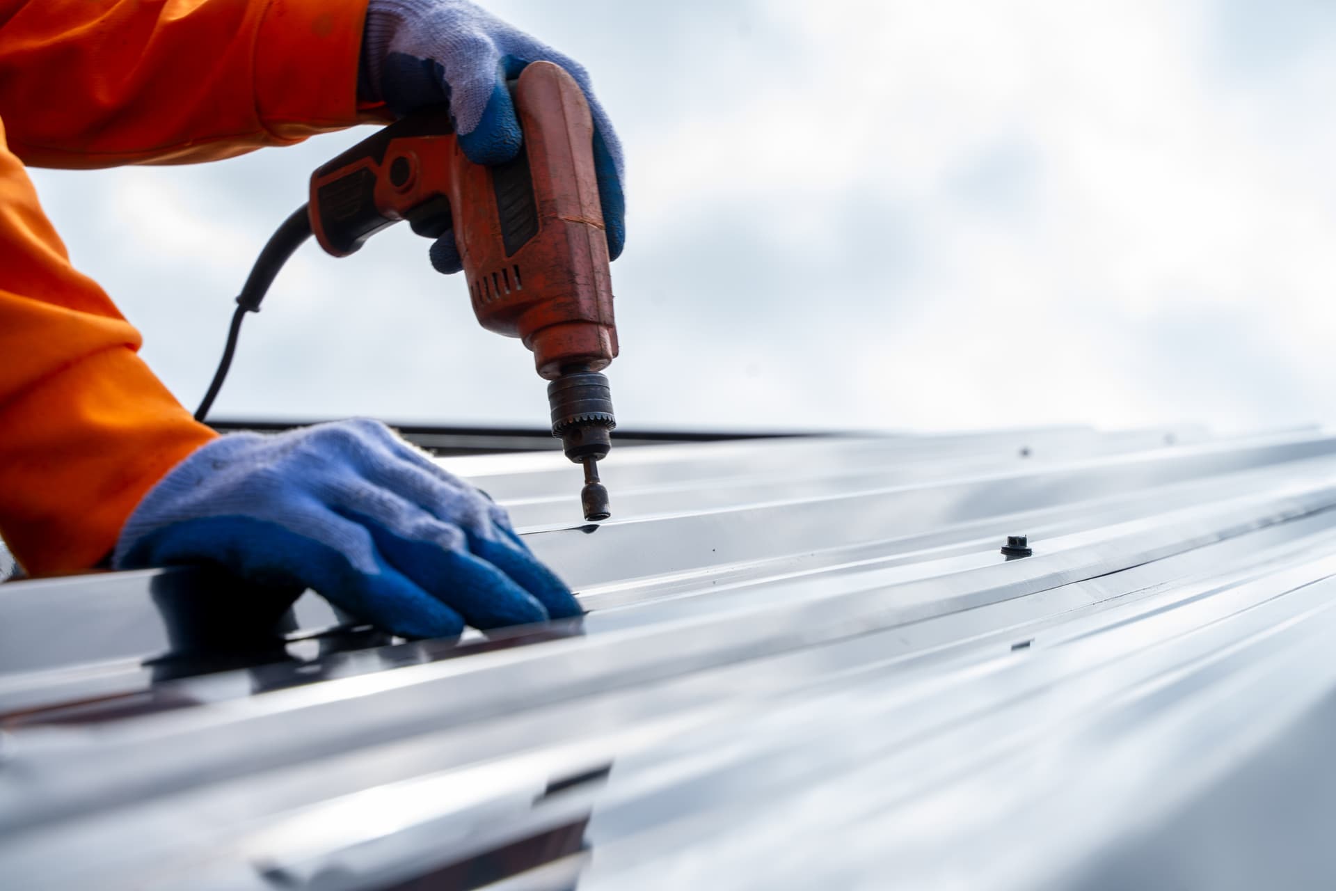 Roofing contractor installing metal roof panels on a Boca Raton home