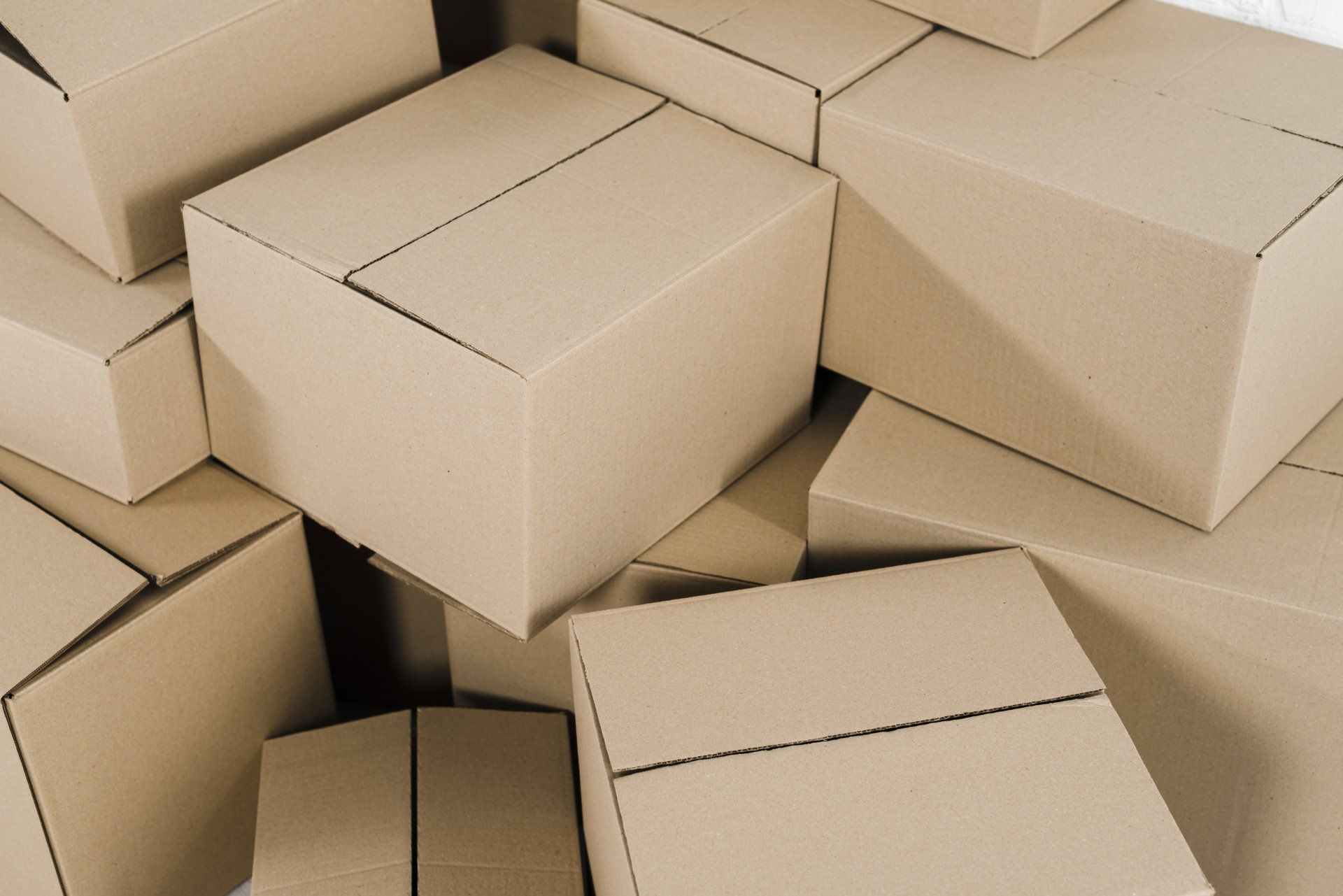 Pila de cajas de cartón sin abrir, de varios tamaños.