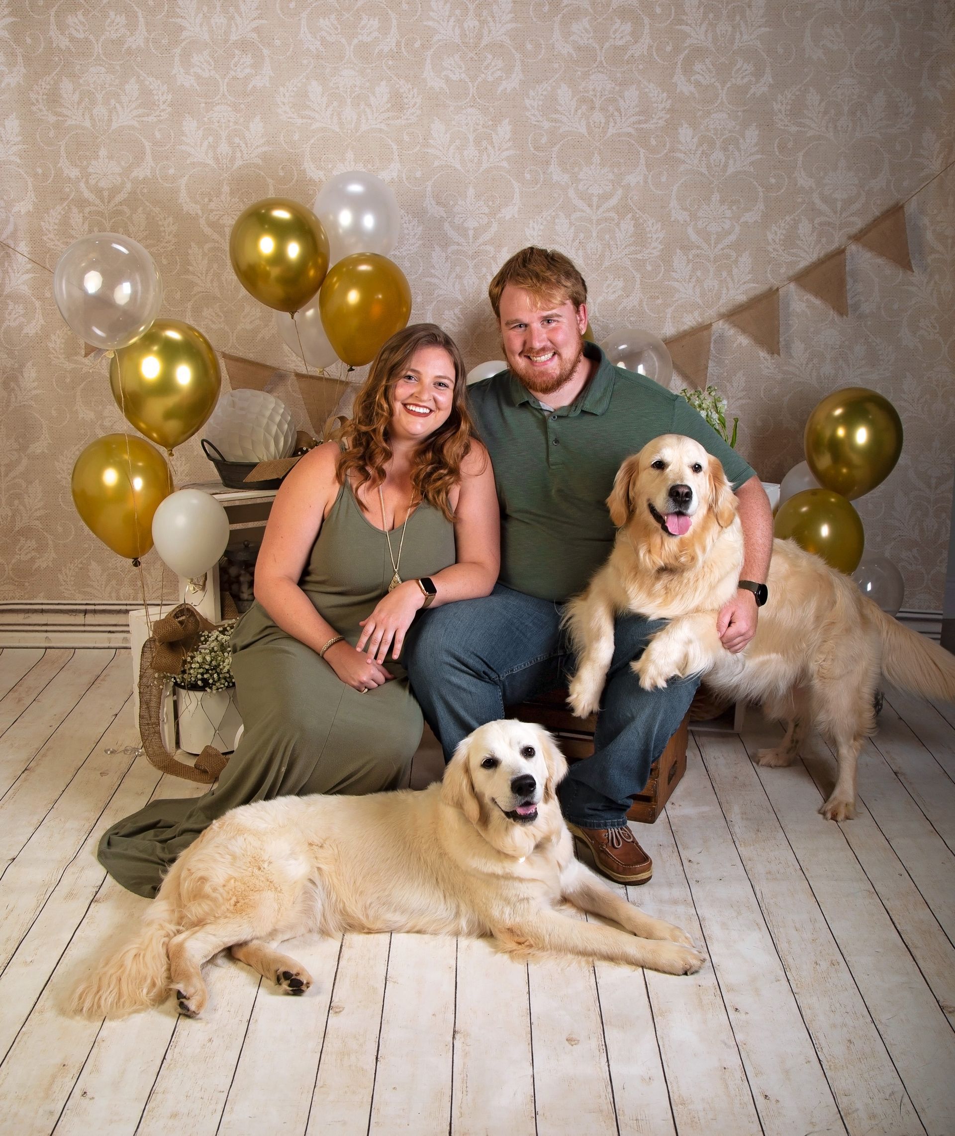 A man and a woman are posing for a picture with two dogs.