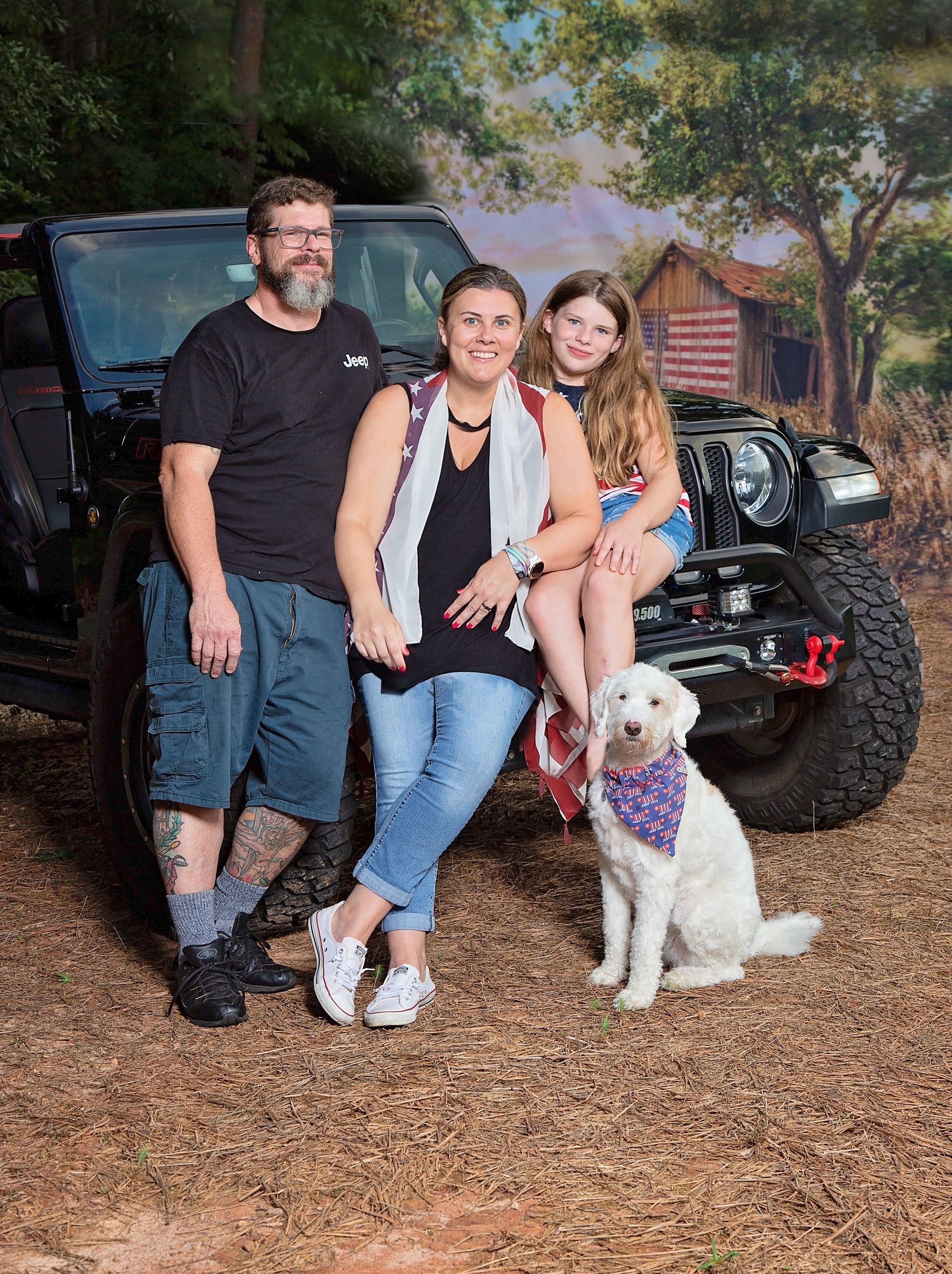 A family is posing for a picture in front of a jeep.