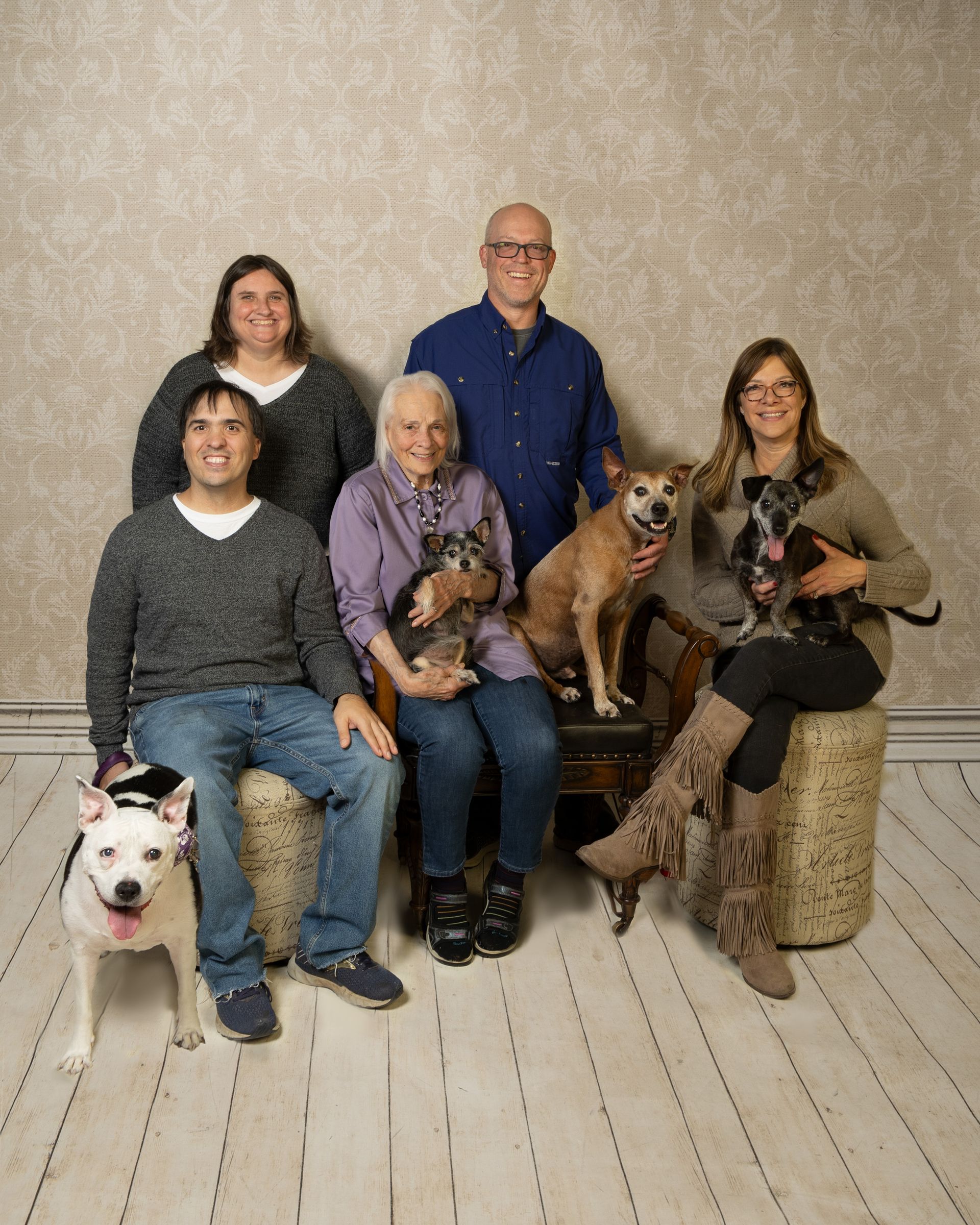 A family posing for a picture with their dogs.