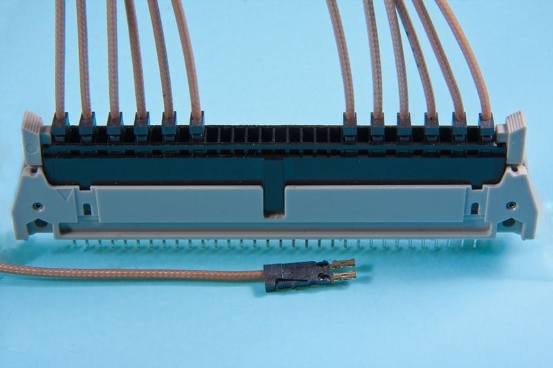 A gray and black connector with multiple wires attached, and a small black connector is detached.