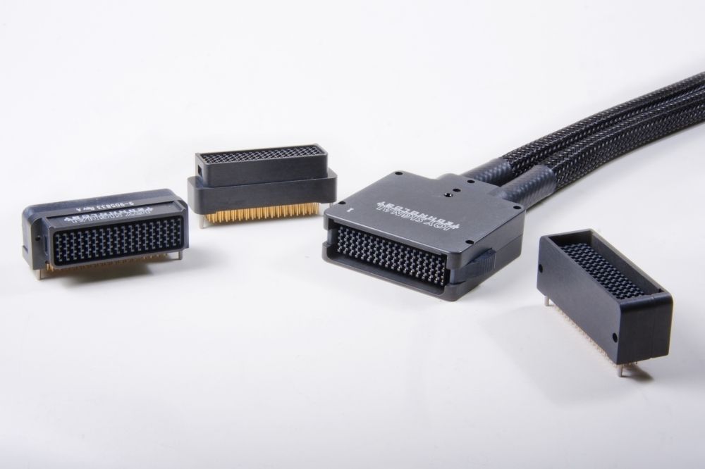 Several black electrical connectors with a cable bundle on a white surface.