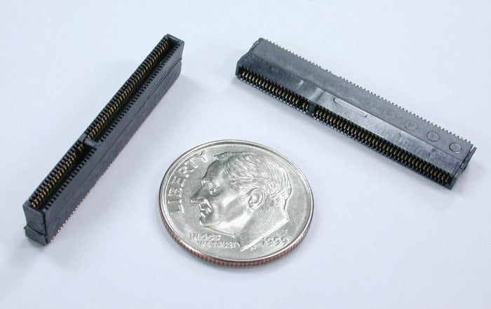 Two small black connectors with pins next to a U.S. dime.