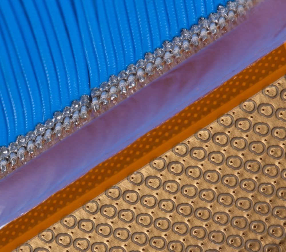 Blue cables layered above a pink section, bordering a patterned gold surface.