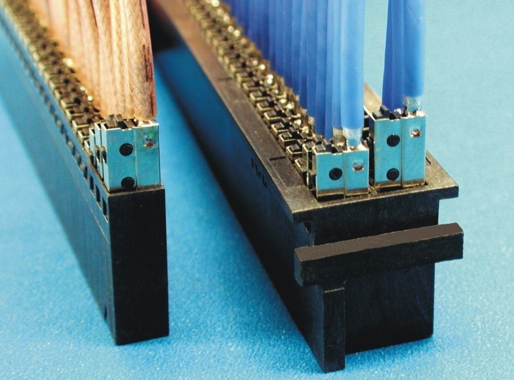Close-up of two black electrical connectors with rows of copper and blue wires extending upwards.