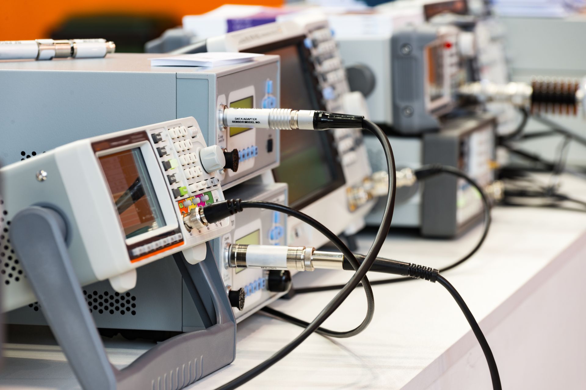 Electronic test equipment, connected by cables, arranged in a row.