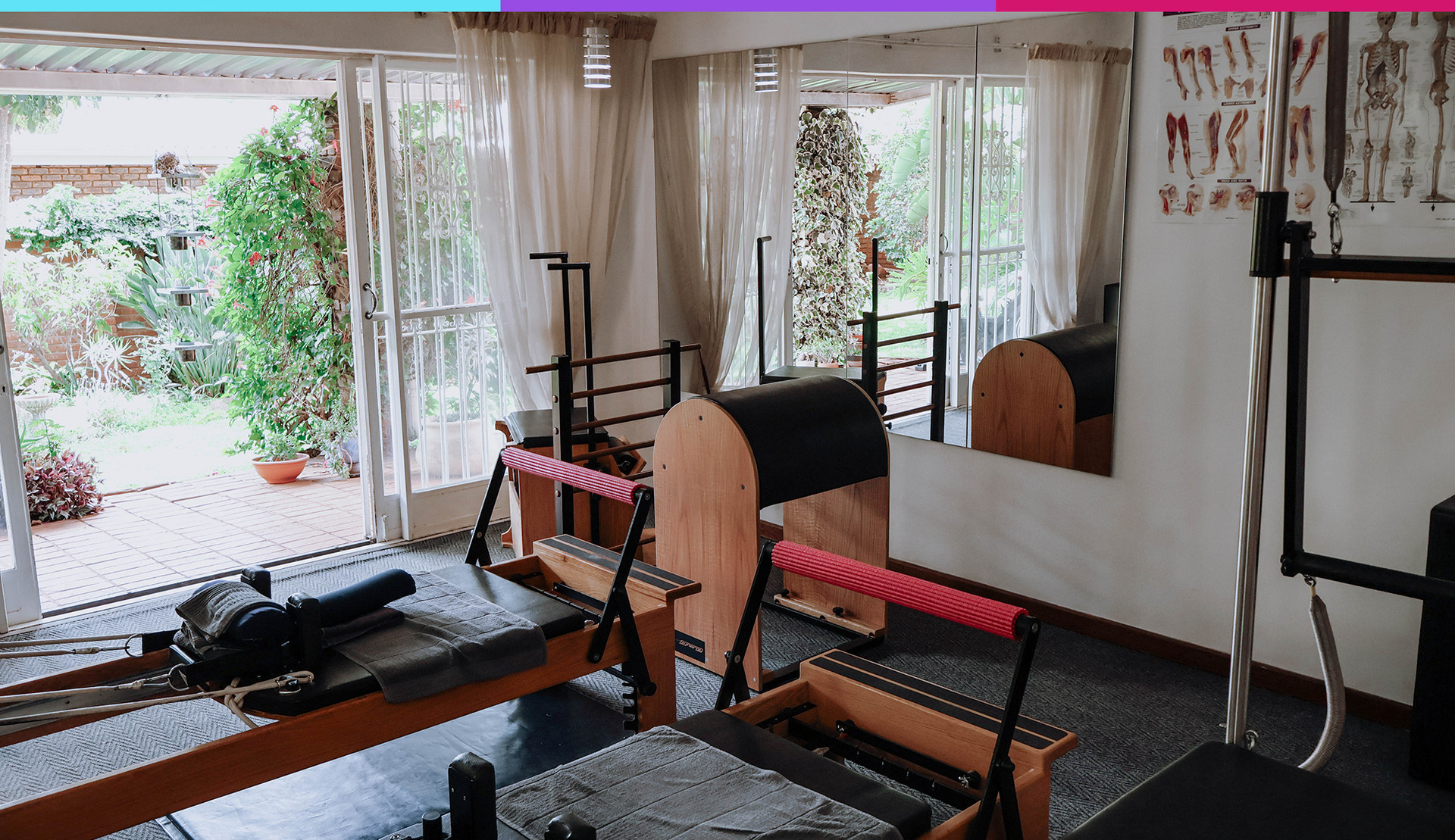 Gym workout room with weight bench, barbell rack, mats, and mirrored walls near an open doorway.