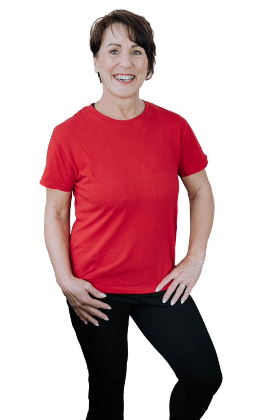 Smiling person in a red T-shirt and black pants standing against a white background.