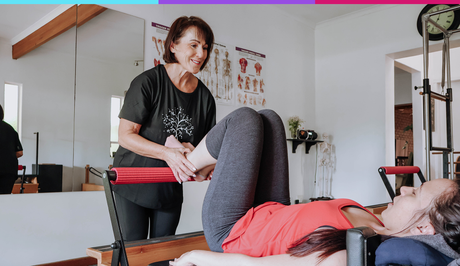 Person receiving a leg stretch from a therapist in a clinic room