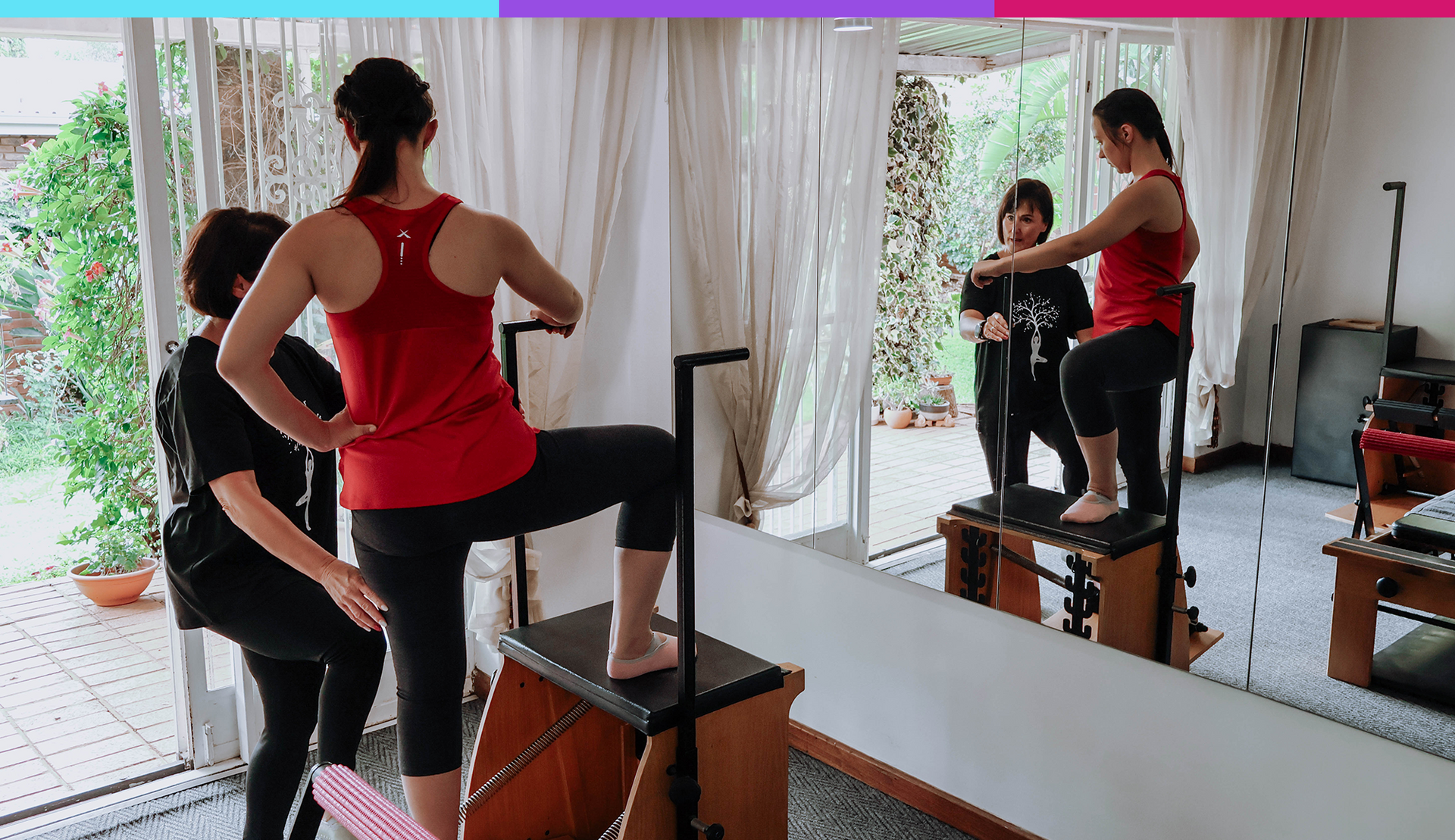 Woman in red tank top exercises on a step in front of a mirrored wall in a bright room.