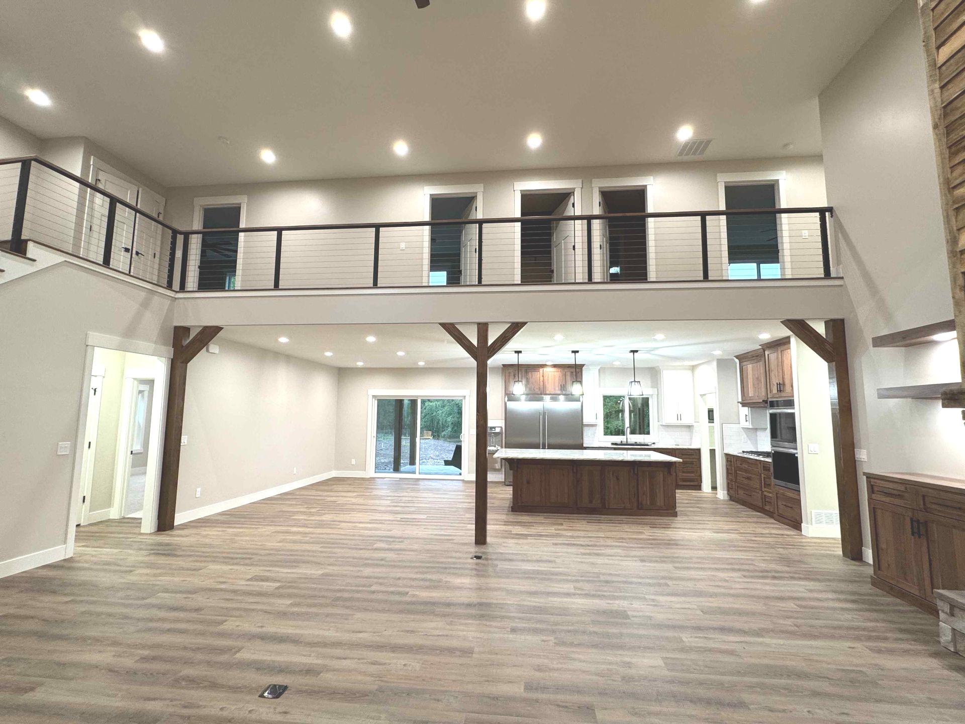 Spacious living room with leather sofas, brick accent wall, and a loft.