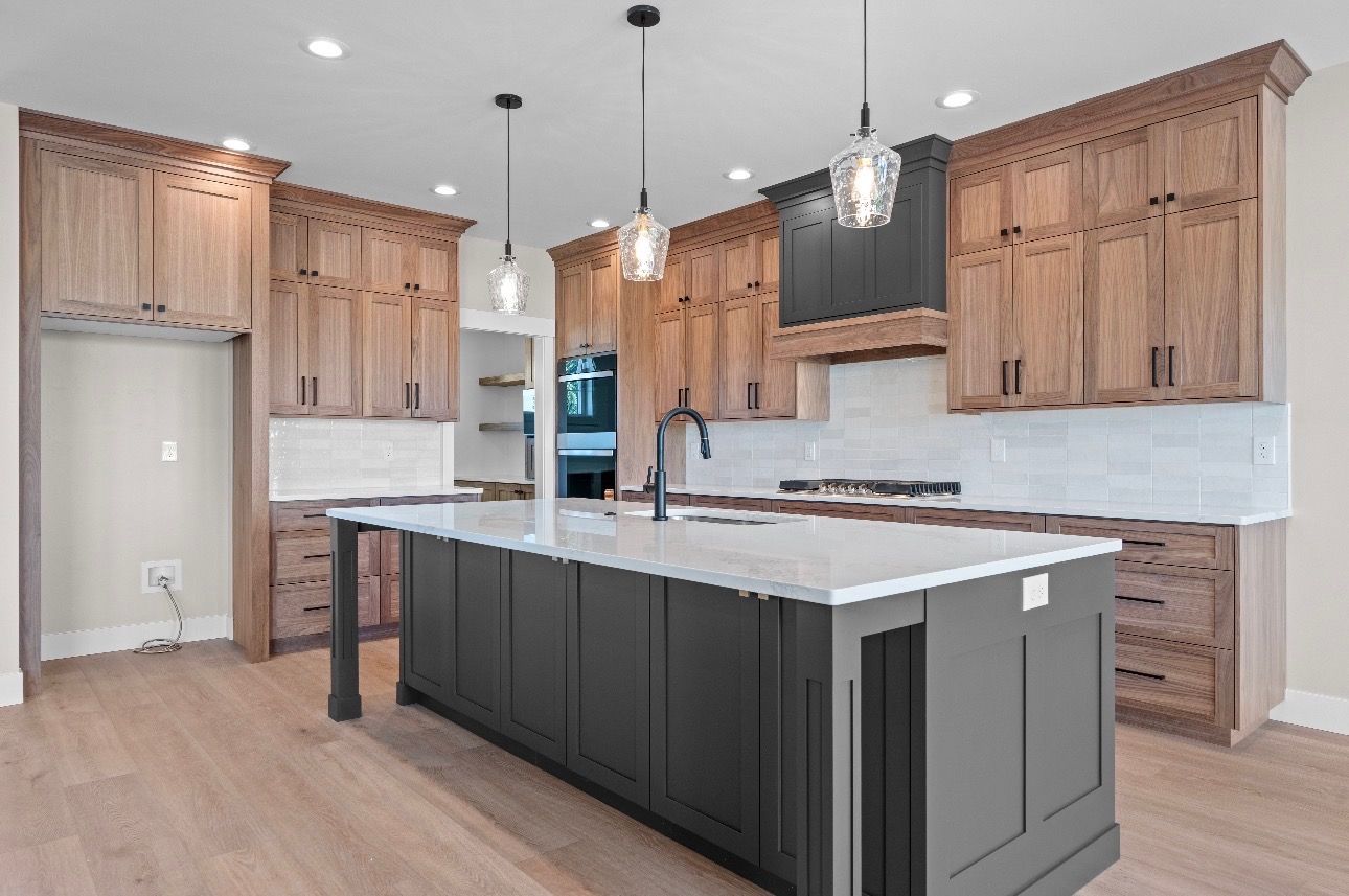 Modern kitchen with wood cabinets, large white island, stainless appliances, and pendant lights