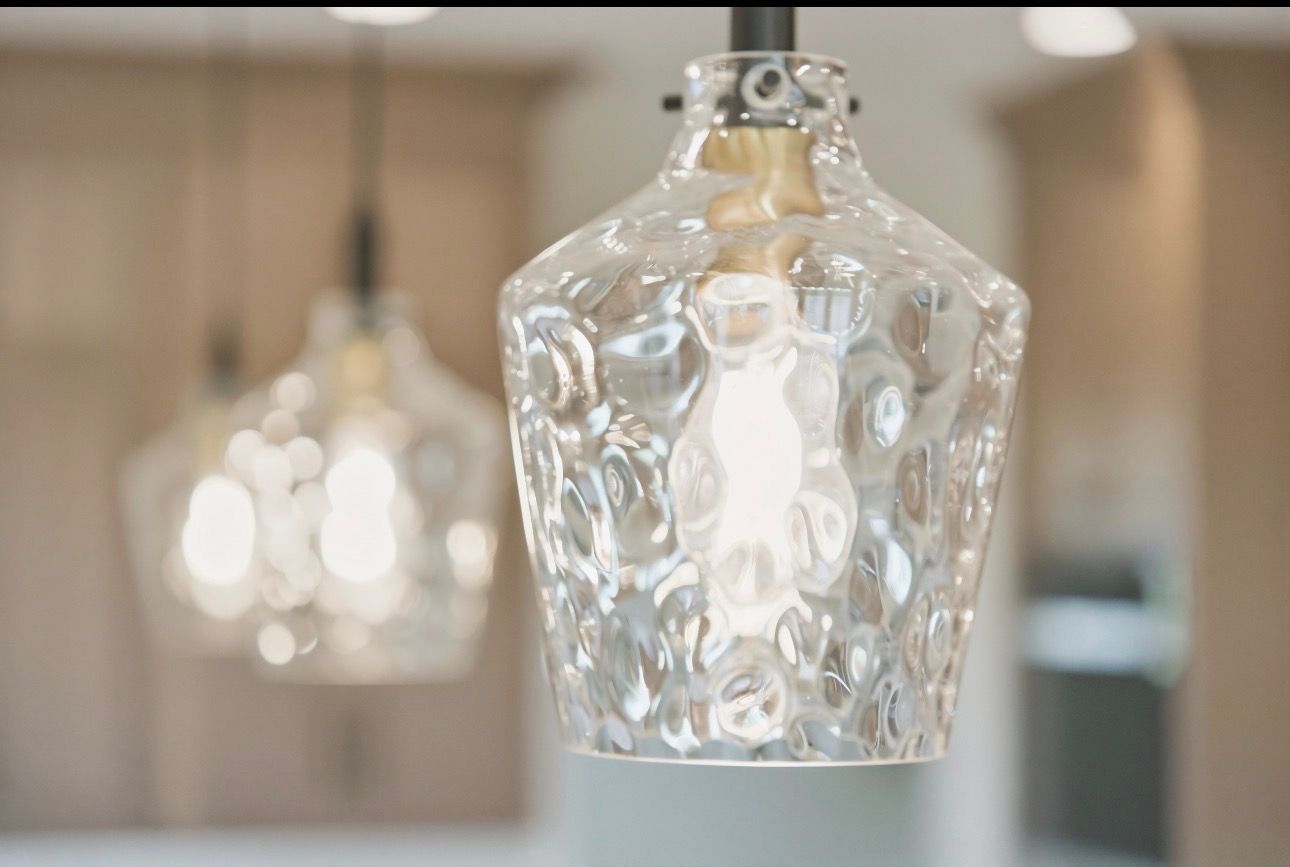 Clear glass pendant lights hanging in a softly blurred interior space