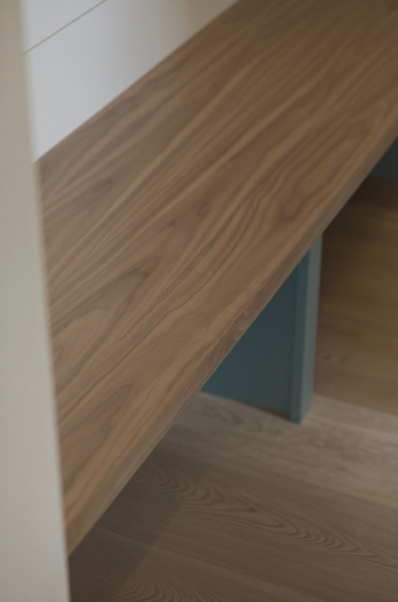 Close-up of a wooden tabletop with a gray support leg underneath
